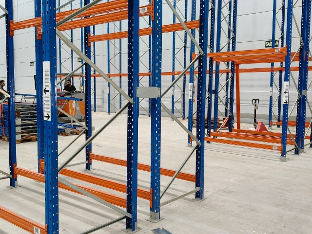 Equipe MBS montando porta-paletes com paleteira em galpão industrial em SC